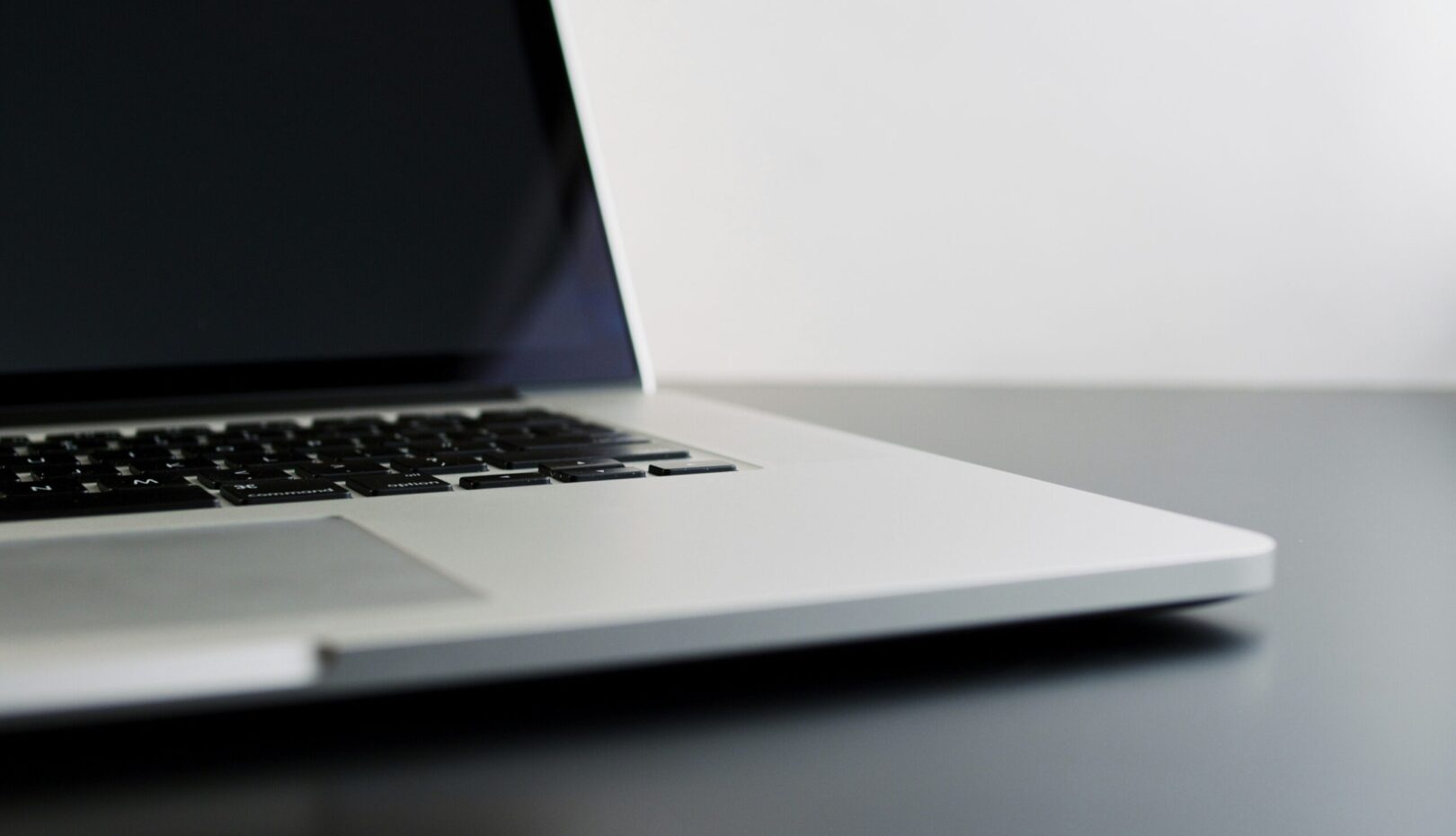 silver laptop computer on black table