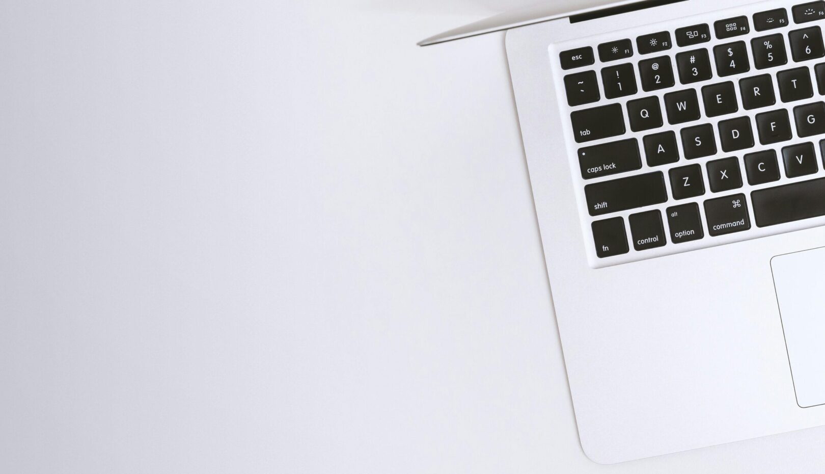 Free Aerial view of a sleek laptop keyboard on a clean, white surface, ideal for tech backgrounds. Stock Photo