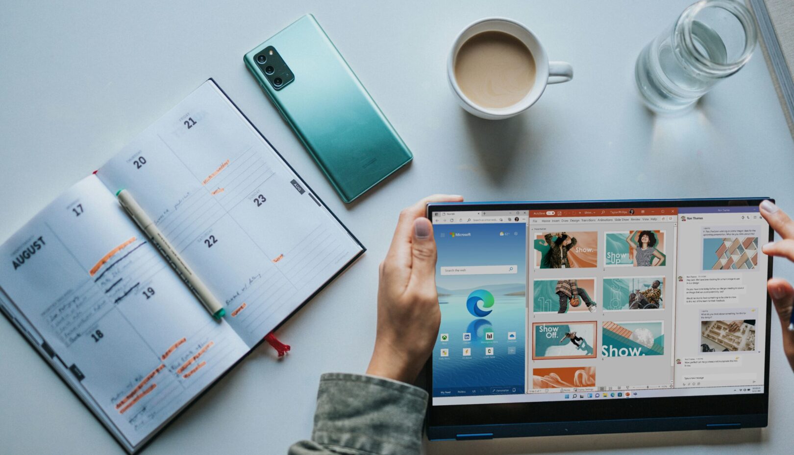 person using Windows 11 computer beside white ceramic mug on white table