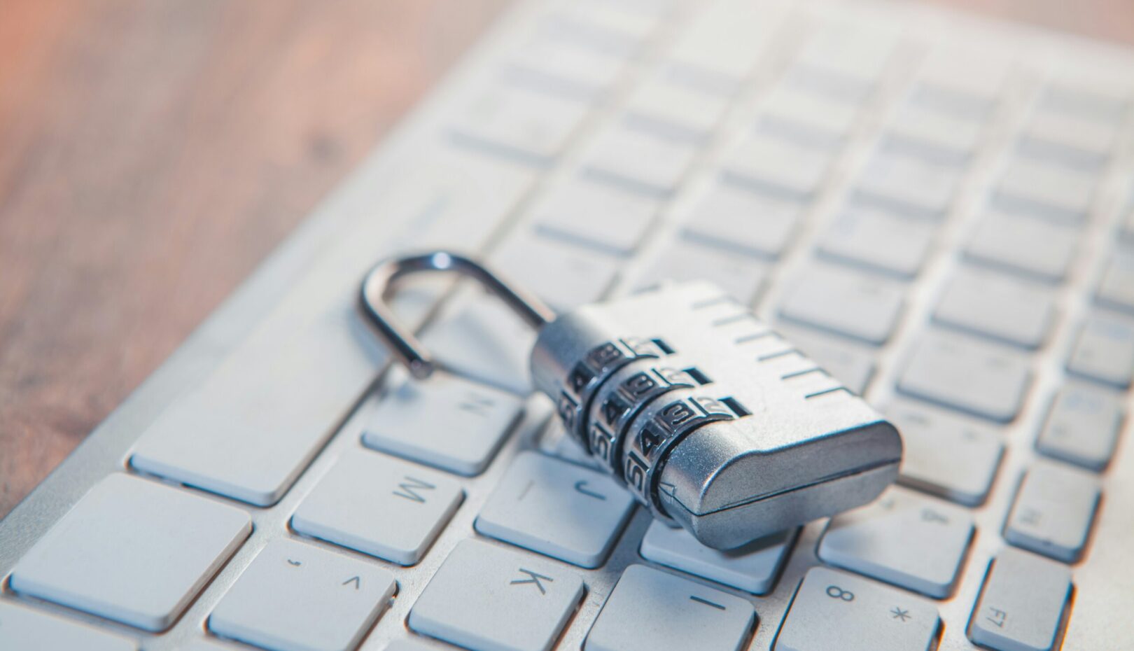 A combination lock rests on a computer keyboard.